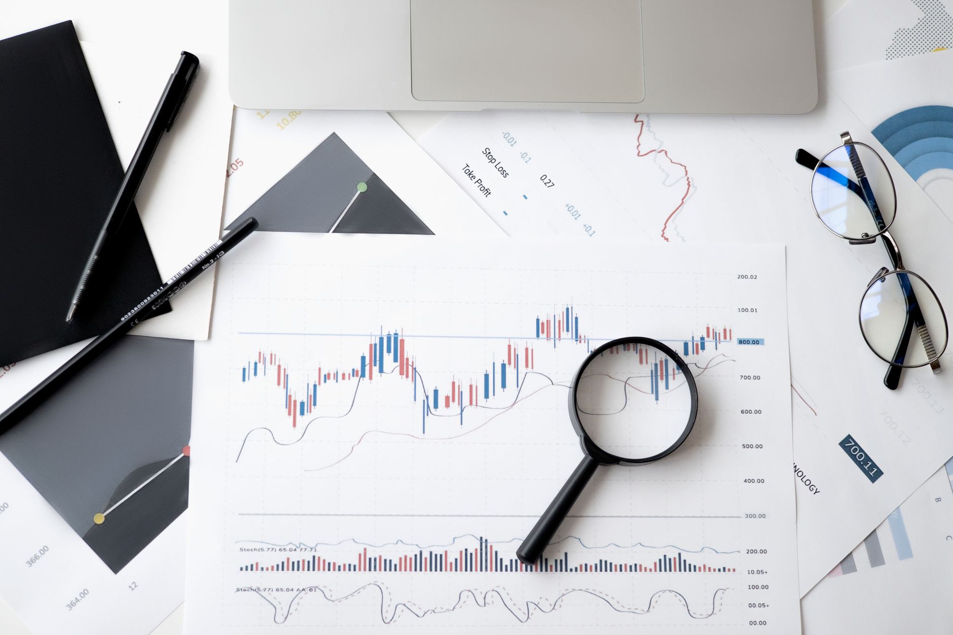 Desk with documents, charts and a laptop for analysis